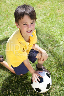 Young Boy Outside Playing With Football or Soccer Ball