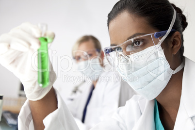 Asian Female Scientist With Laboratory Test Tube of Green Soluti