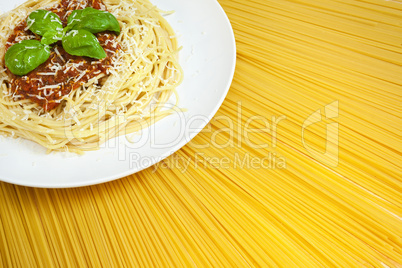 Plate of Spaghetti Bolognese on A Sunny Display of Dried Pasta