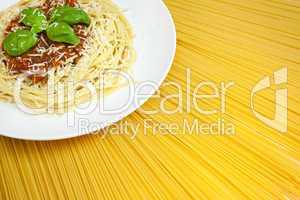 Plate of Spaghetti Bolognese on A Sunny Display of Dried Pasta