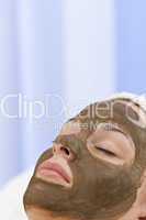 Young Woman Having Chocolate Face Mask Facial At Health Spa