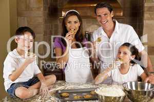 Attractive Family Baking and Eating Cookies In A Kitchen