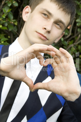 Teen boy making heart shape with hands