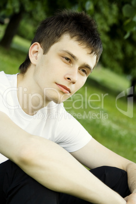 Young man sits in the park