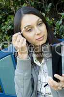 Young woman adjusts makeup