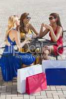 Three Beautiful Young Women Having Coffee With Shopping Bags