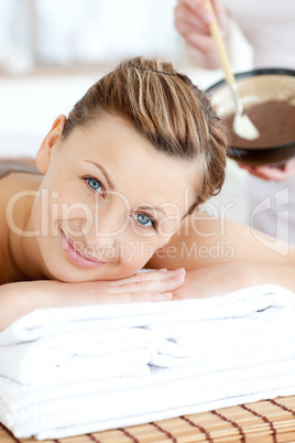 Smiling woman enjoying a mud treatment