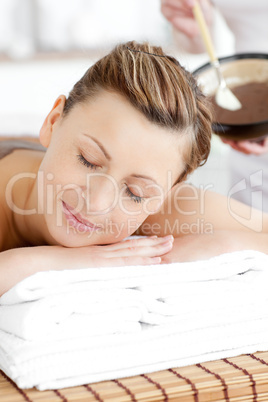 Peaceful woman enjoying a mud treatment