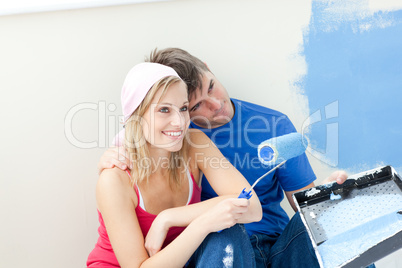 Affectionate couple painting a room