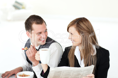 Cheerful couple of business people having breakfast