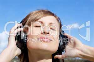 Beautiful woman listenng music outdoors