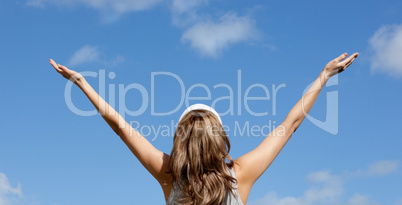 Caucasian blond woman punching tha air against blue sky