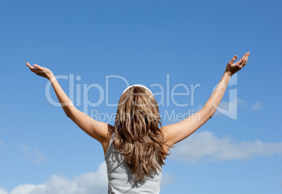 Blond woman relaxing against blue sky