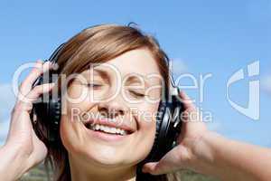 Smiling woman listenng music outdoors