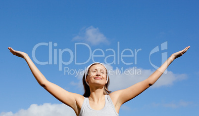 Glowing woman relaxing against blue sky