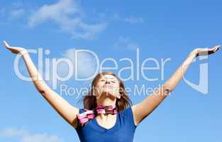 Radiant blond woman punching tha air against blue sky