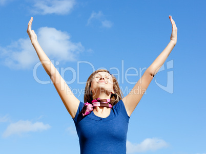 Jolly  blond woman punching tha air against blue sky
