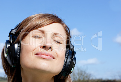 Relaxed woman listenng music outdoors