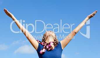 Relaxed  blond woman punching tha air against blue sky