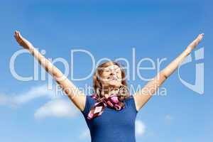 Young  blond woman punching tha air against blue sky