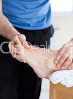 Close-up of a male physical therapist giving a foot massage