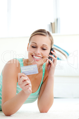 Smiling woman on phone and holding a credit card