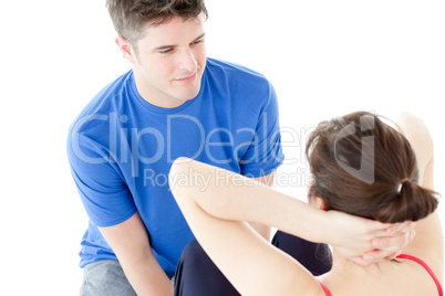 Young woman exercising assisted by a personal coach