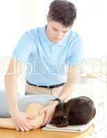 Handsome physical therapist giving a back massage