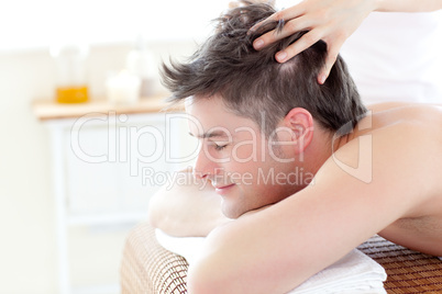 Handsome young  man receiving a head massage