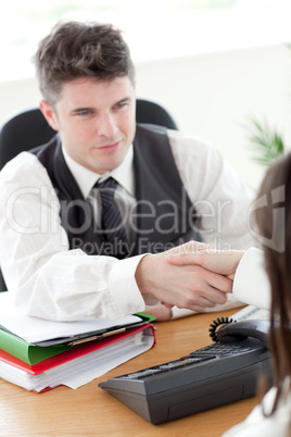 Handsome businessman and his colleague shaking hands