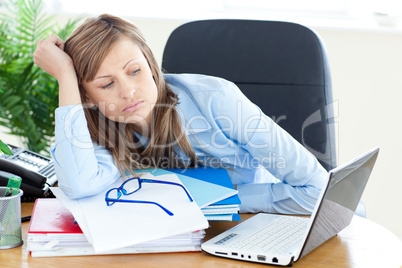 Stressed young businesswoman sitting at her desk