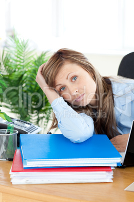Upset young businesswoman sitting at her desk