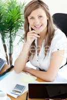 Happy businesswoman sitting at her desk