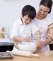 Adorable little boy preparing cookies with her mother