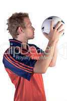 Football player posing with ball in hands on a white background