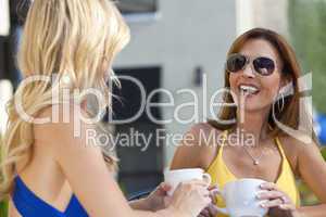 Two Beautiful Young Women Laughing and Drinking Coffee
