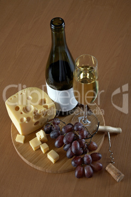 Bottle and glass of white wine with cheese