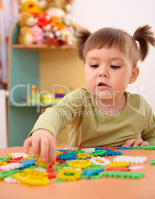 Little girl play with building bricks in preschool