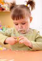Little girl sharpening a pencil