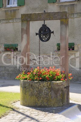 Brunnen mit Blumen im Elsaß