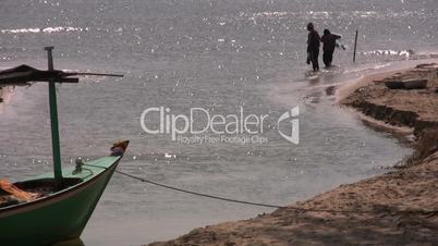 Thai fishermen cast nets into ocean.