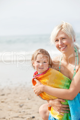A cheerful girl and her smiling mother at the beach