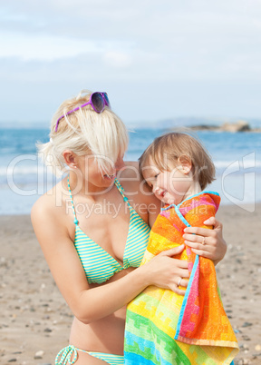 A bright mother with her smiling daughter at the beach