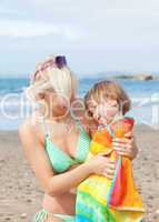 A bright mother with her smiling daughter at the beach