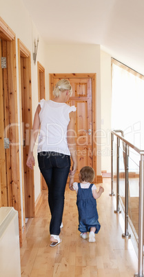 Mother wakling with her daughter on the floor