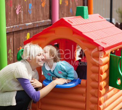 Cute girl kissing her smiling mother