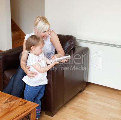 Girl holding a remote control standing in the living room