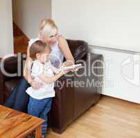 Girl holding a remote control standing in the living room