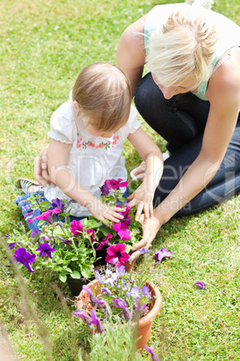 Sweet child helping her mother in the garden