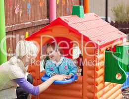 Sweet girl standing in a small house at the playground